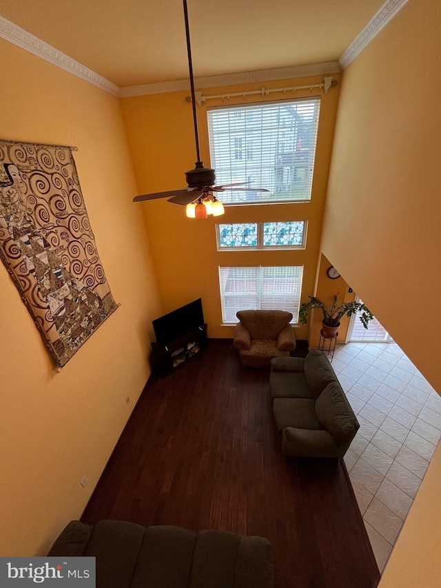 living room with ceiling fan, ornamental molding, and light wood-type flooring