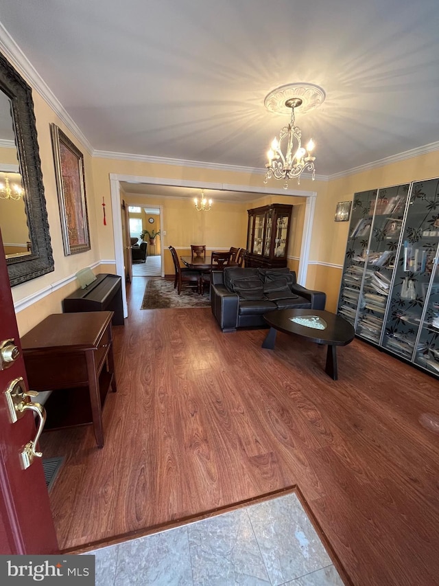 living room featuring crown molding, a chandelier, and wood-type flooring