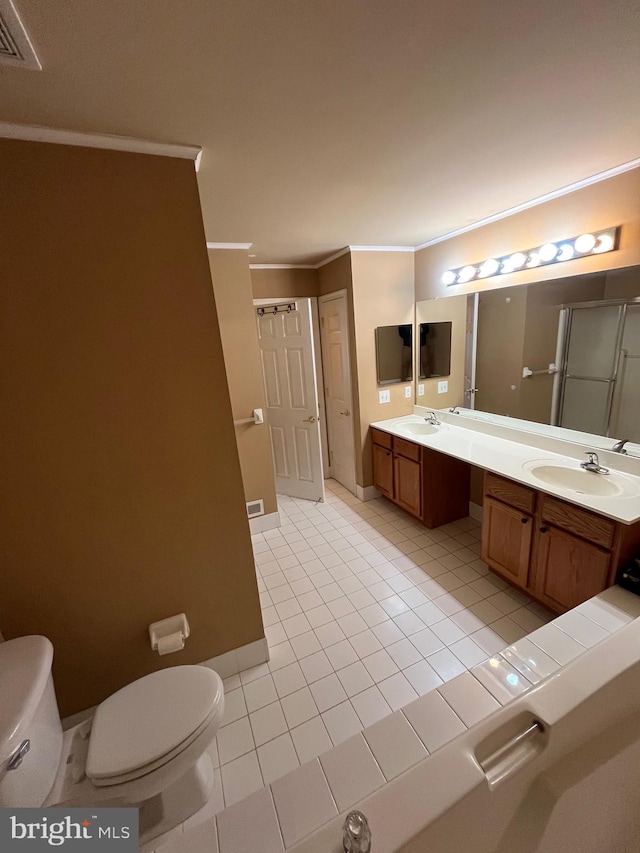 bathroom with tile patterned floors, crown molding, vanity, and toilet