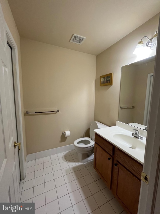 bathroom with tile patterned flooring, vanity, and toilet