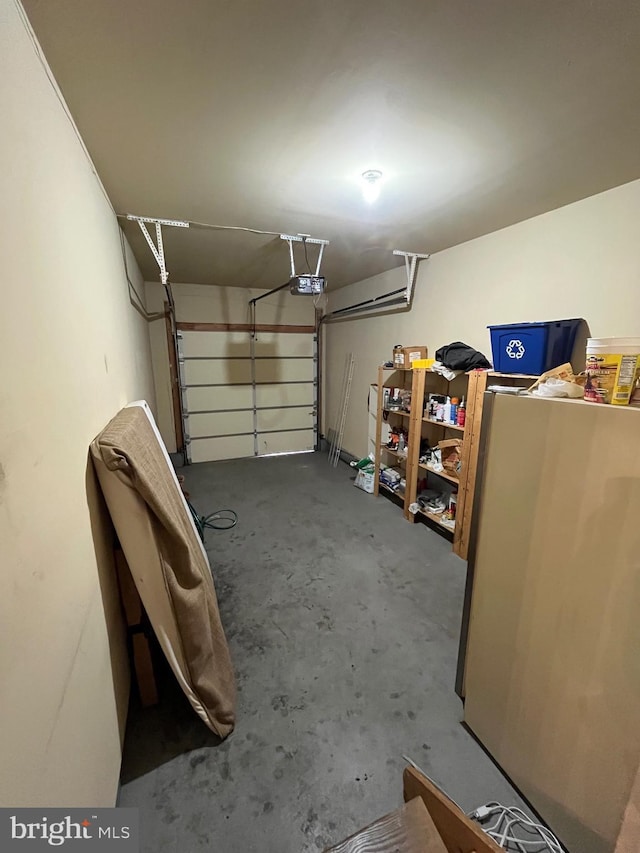 garage with stainless steel fridge and a garage door opener