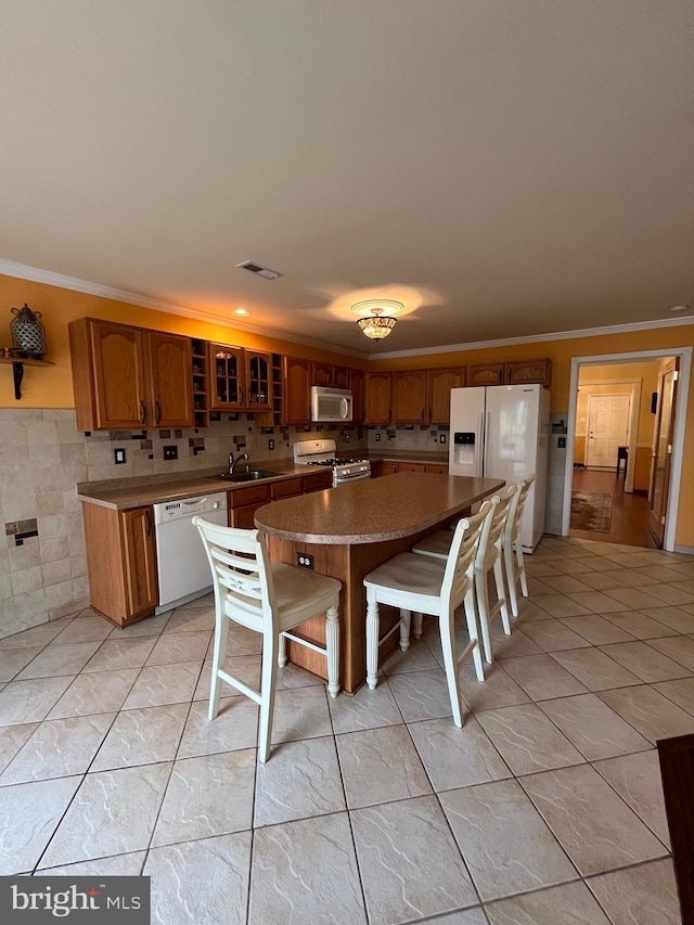 dining space with light tile patterned floors, crown molding, and sink