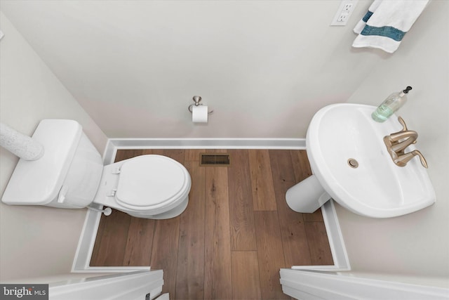 bathroom featuring sink, hardwood / wood-style floors, and toilet