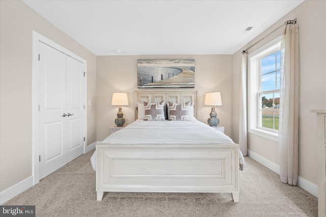 bedroom with light carpet and a closet