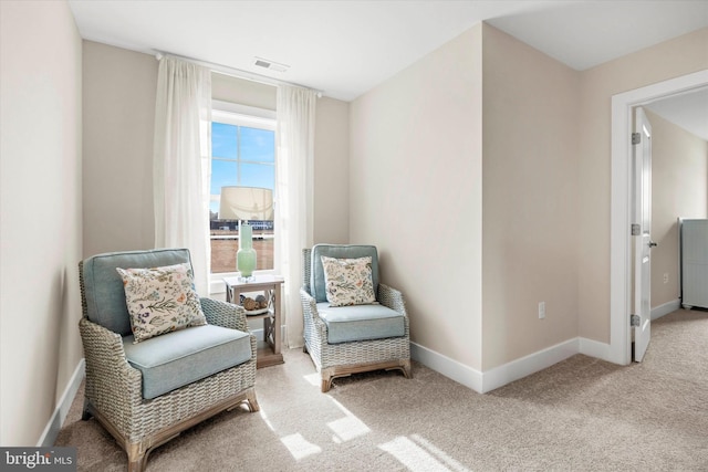 living area featuring light carpet