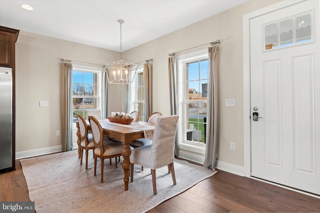 dining area featuring dark hardwood / wood-style flooring, an inviting chandelier, and plenty of natural light