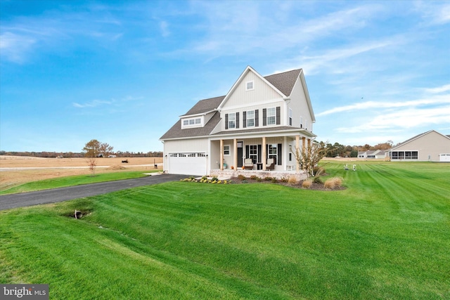 view of front of property with a garage, covered porch, and a front yard