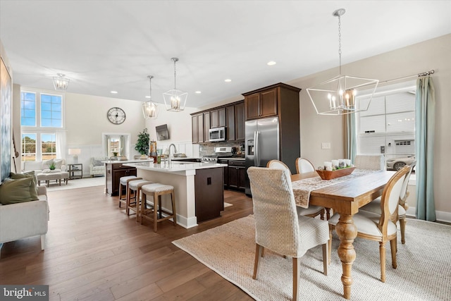 dining room featuring a notable chandelier, wood-type flooring, and sink