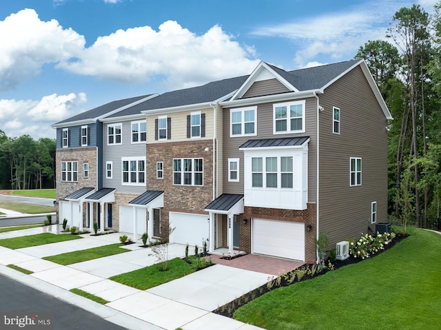 view of front of home with a front yard, a garage, and central air condition unit