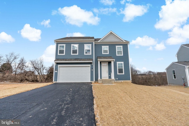 traditional home featuring a garage and aphalt driveway