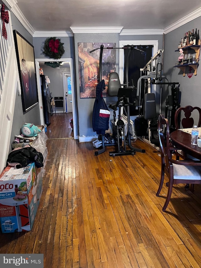 workout area featuring hardwood / wood-style floors and ornamental molding