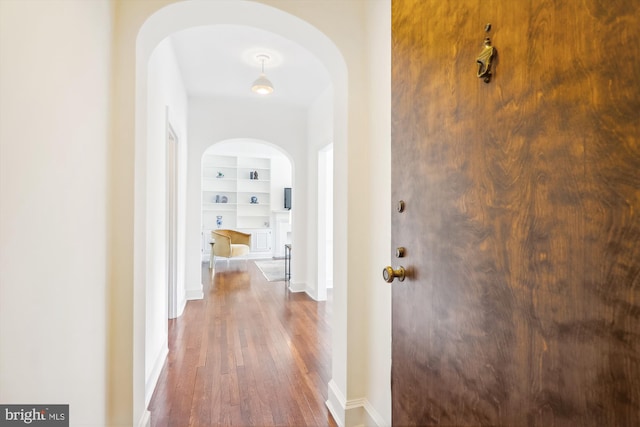 hall featuring dark hardwood / wood-style flooring and built in features