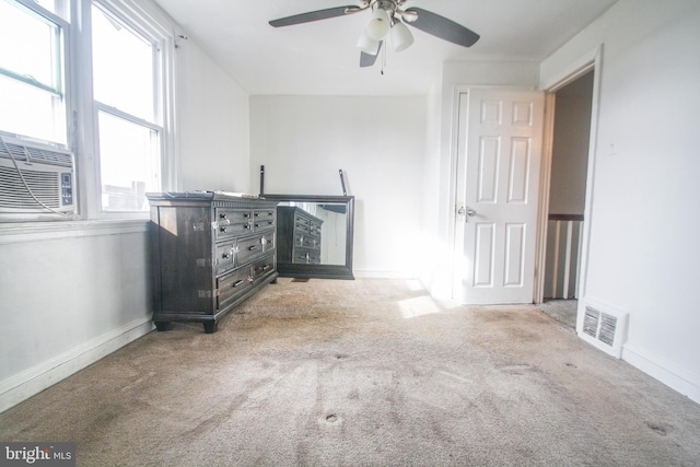 interior space with ceiling fan, cooling unit, and light colored carpet