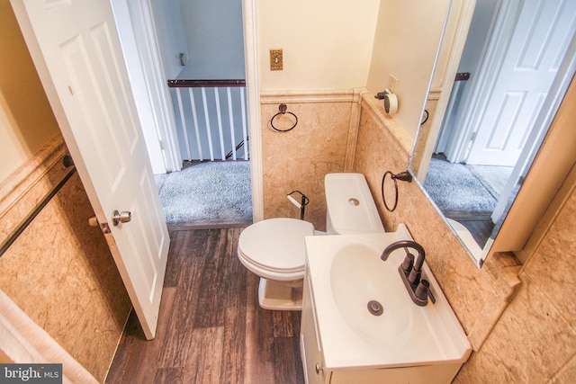 bathroom featuring hardwood / wood-style floors, vanity, tile walls, and toilet