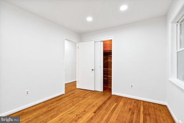 unfurnished bedroom with a closet and light hardwood / wood-style flooring