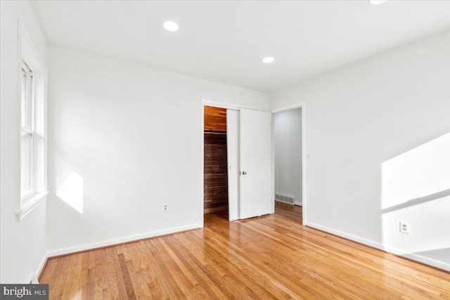 unfurnished bedroom with light hardwood / wood-style flooring and a closet