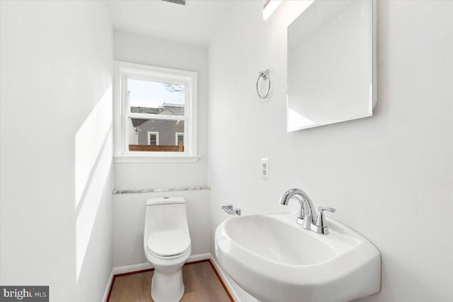 bathroom featuring sink, hardwood / wood-style floors, and toilet