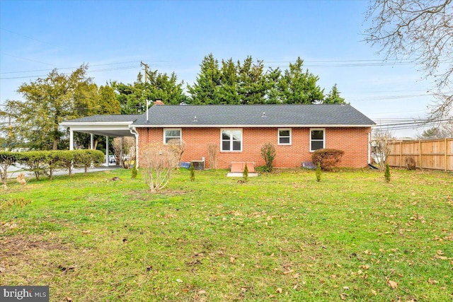 rear view of house featuring a yard, central AC unit, and a carport