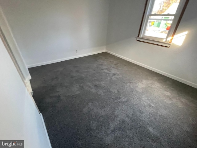 empty room featuring dark colored carpet