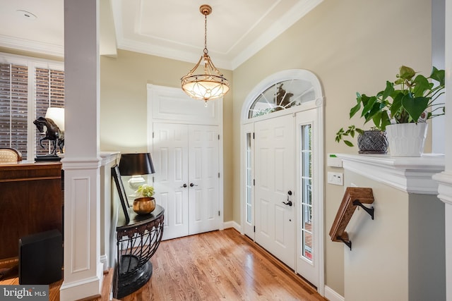 entryway with crown molding and light hardwood / wood-style floors