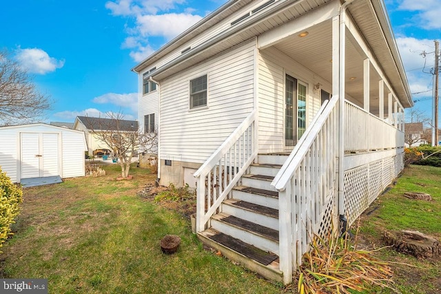 rear view of property featuring a yard and a storage shed