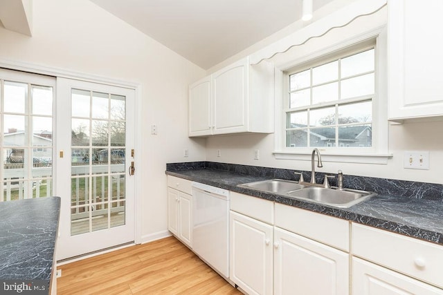 kitchen with lofted ceiling, white dishwasher, white cabinets, sink, and light hardwood / wood-style flooring