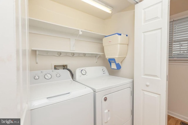 clothes washing area featuring separate washer and dryer and hardwood / wood-style flooring