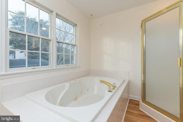 bathroom featuring wood-type flooring and shower with separate bathtub