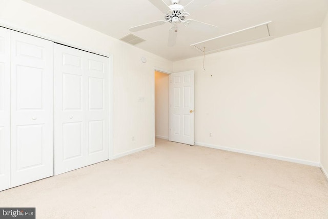 unfurnished bedroom with ceiling fan, light colored carpet, and a closet