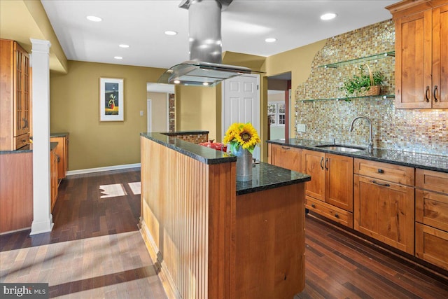 kitchen with island range hood, decorative backsplash, dark wood finished floors, and a sink