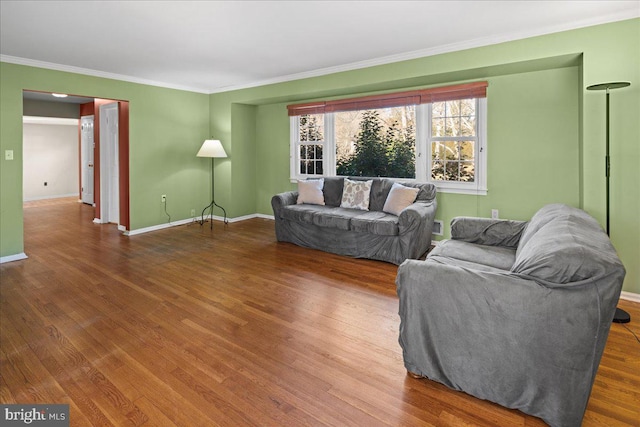 living area featuring crown molding, wood finished floors, and baseboards