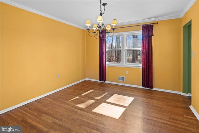 empty room with a notable chandelier, visible vents, wood finished floors, and ornamental molding