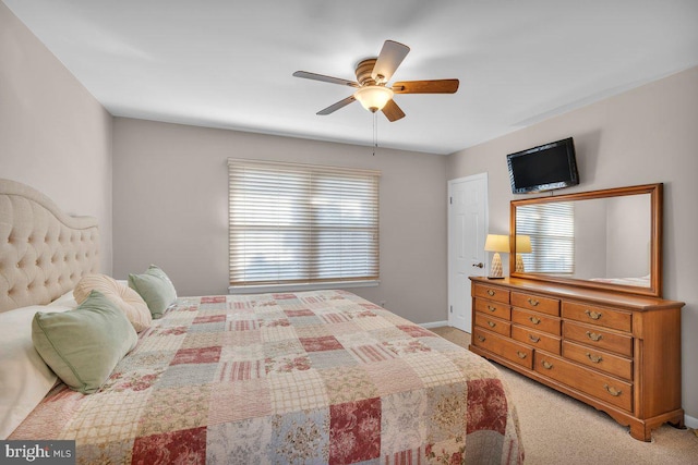 bedroom featuring ceiling fan, light colored carpet, and multiple windows