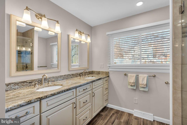 bathroom featuring walk in shower, vanity, and hardwood / wood-style flooring