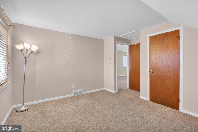 unfurnished room featuring carpet flooring, plenty of natural light, and lofted ceiling