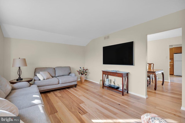 living room featuring hardwood / wood-style flooring and vaulted ceiling