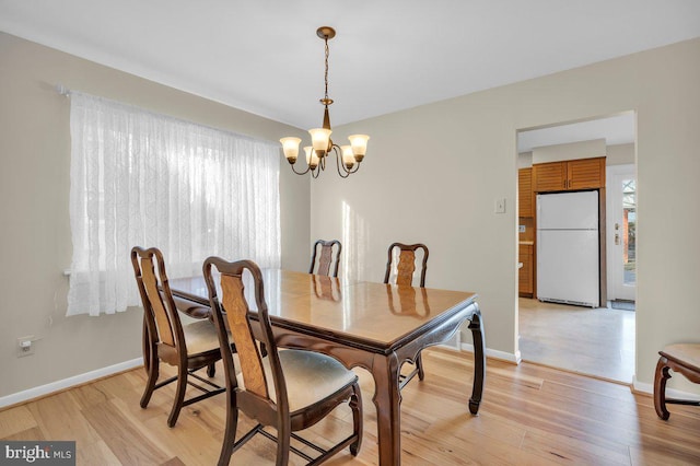 dining room featuring light hardwood / wood-style floors, an inviting chandelier, and a healthy amount of sunlight