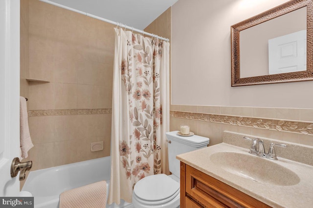 full bathroom with vanity, shower / bath combo, toilet, and tile walls