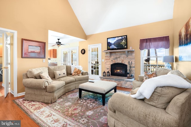 living room with a fireplace, hardwood / wood-style flooring, high vaulted ceiling, and ceiling fan