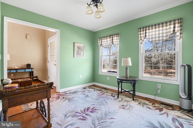 misc room with wood-type flooring and an inviting chandelier