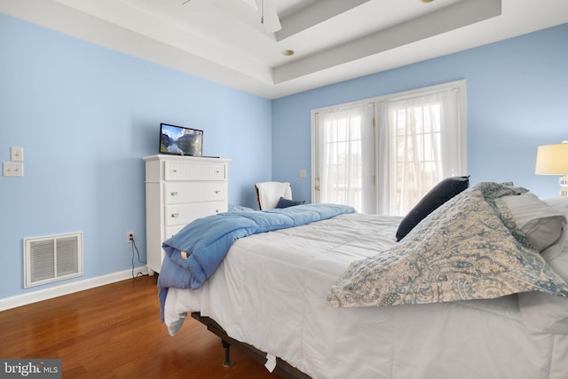 bedroom featuring a tray ceiling, ceiling fan, and hardwood / wood-style floors