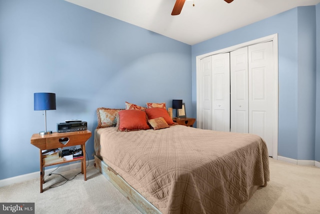 carpeted bedroom with ceiling fan and a closet