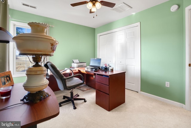 carpeted office space featuring ceiling fan