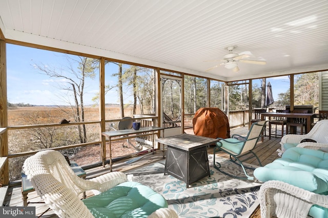 sunroom / solarium featuring ceiling fan and plenty of natural light