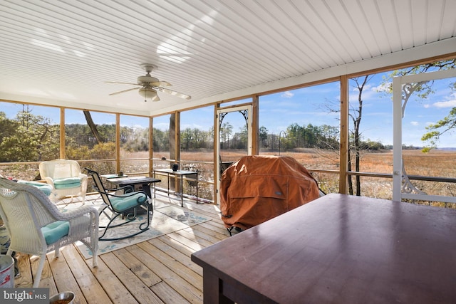 sunroom / solarium with ceiling fan, a rural view, and plenty of natural light