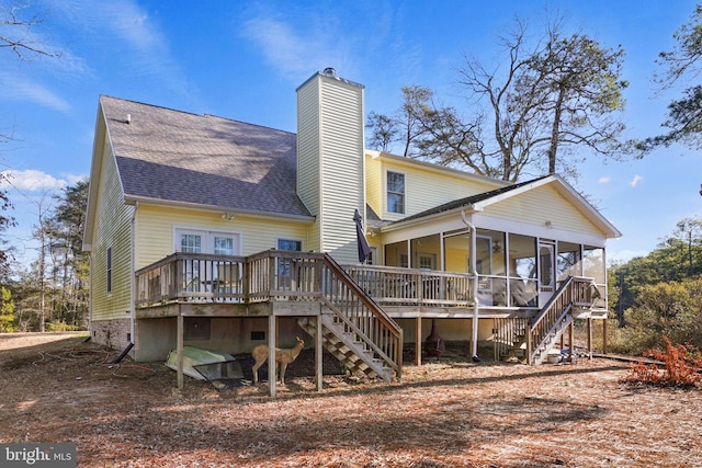 back of property featuring a deck and a sunroom