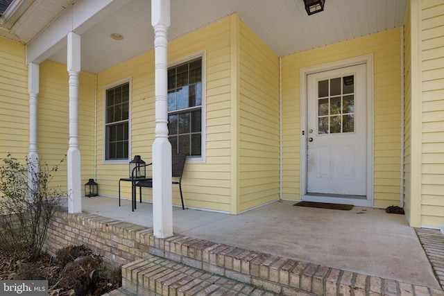 view of exterior entry featuring covered porch