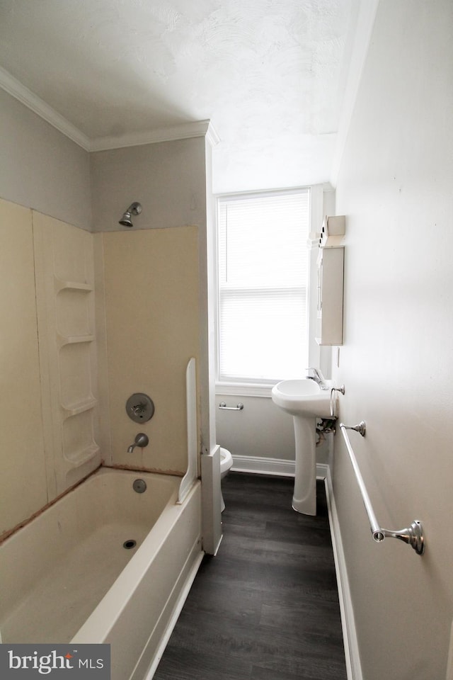 full bathroom featuring hardwood / wood-style floors, toilet, ornamental molding, and bathing tub / shower combination