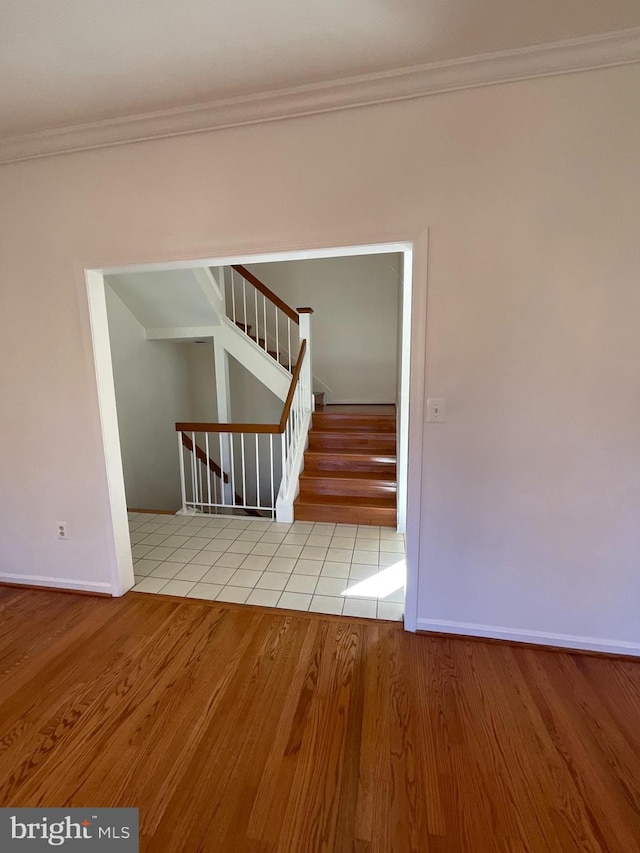 spare room featuring light wood-type flooring and ornamental molding