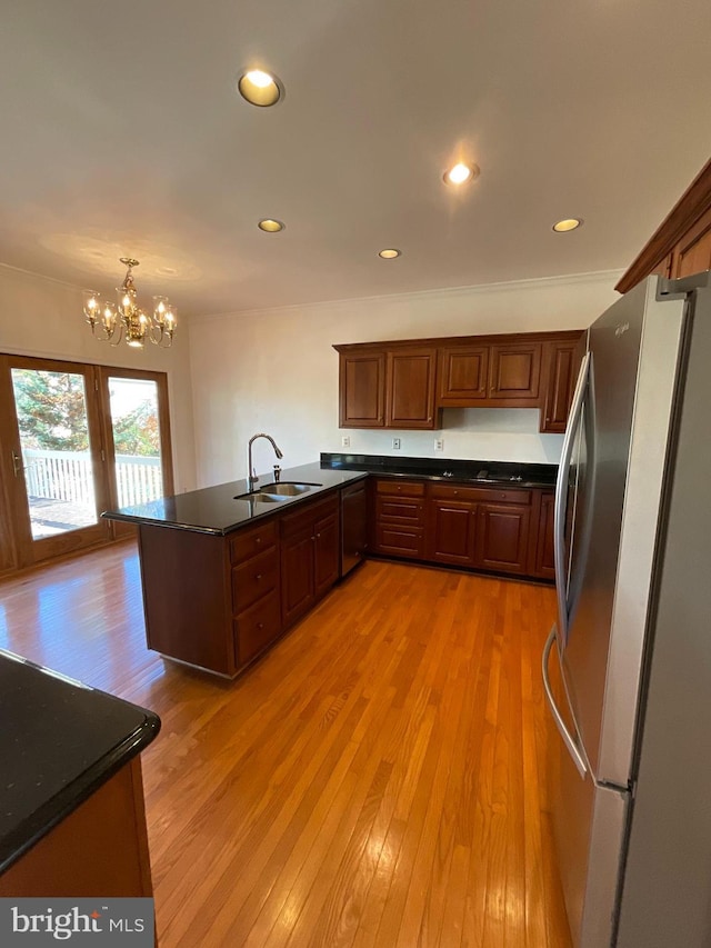 kitchen with kitchen peninsula, stainless steel refrigerator, sink, and light wood-type flooring